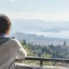 遠くの景色を見つめながら、ひとり静かに立つ女性の後ろ姿